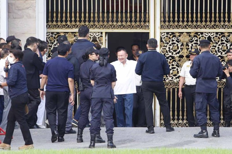 Thaksin Shinawatra smiles widely and opens his arms to hug waiting members of his family as he emerges through the gate of Klongprem Central Prison in Bangkok on Monday morning. (Photo: Pattarapong Chatpattarasill)