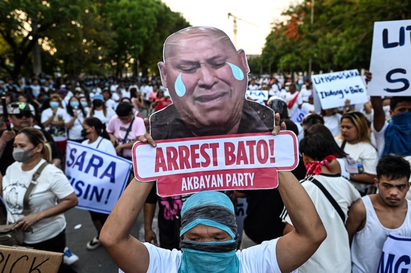 An activist displays a sign calling for the arrest of Senator Ronald “Bato” dela Rosa, during a protest outside the Philippine Senate in Pasay City, Metro Manila, on May 13, 2026. Dela Rosa, the chief enforcer of former president Rodrigo Duterte’s drug war, is wanted on an International Criminal Court warrant. (Photo: Reuters)