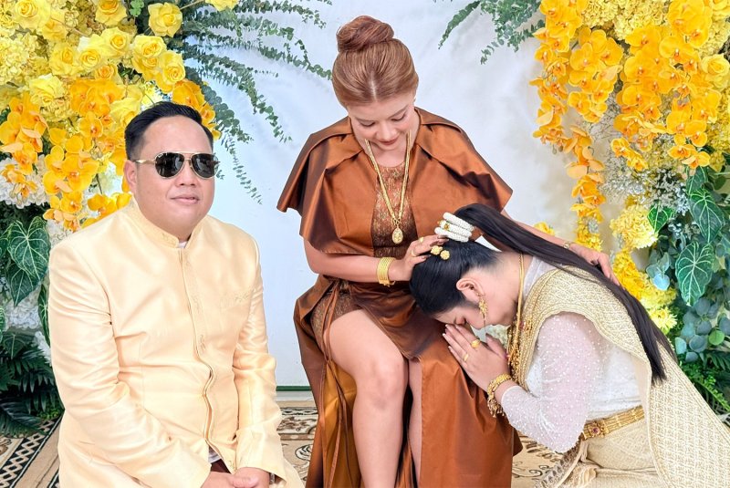 Onuma Chanpheng, the second wife of Witsanu Prangchaiyaphum, pays her respects to Yupin Thadthai, the first wife, who organised the wedding ceremony in Muang district of Chaiyaphum for her husband and his new partner. (Photo: Makkawan Wannakul)