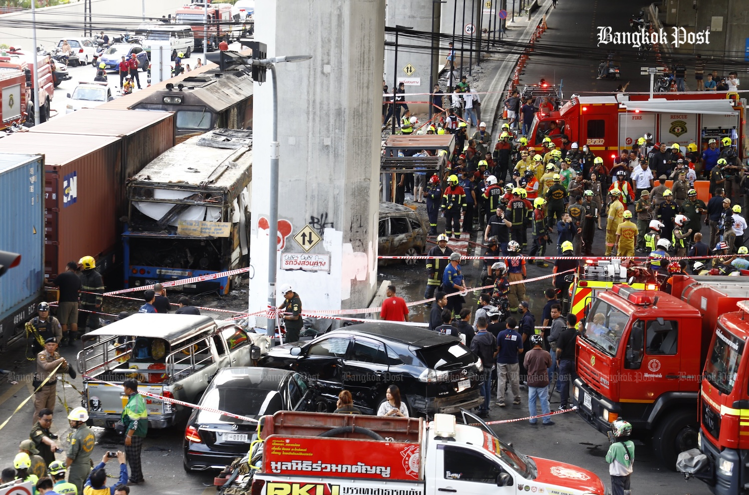 Firefighters and rescue teams work at the scene of the collision, in Huai Khwang district of Bangkok on Saturday afternoon. (Photos: Nutthawat Wichieanbut)