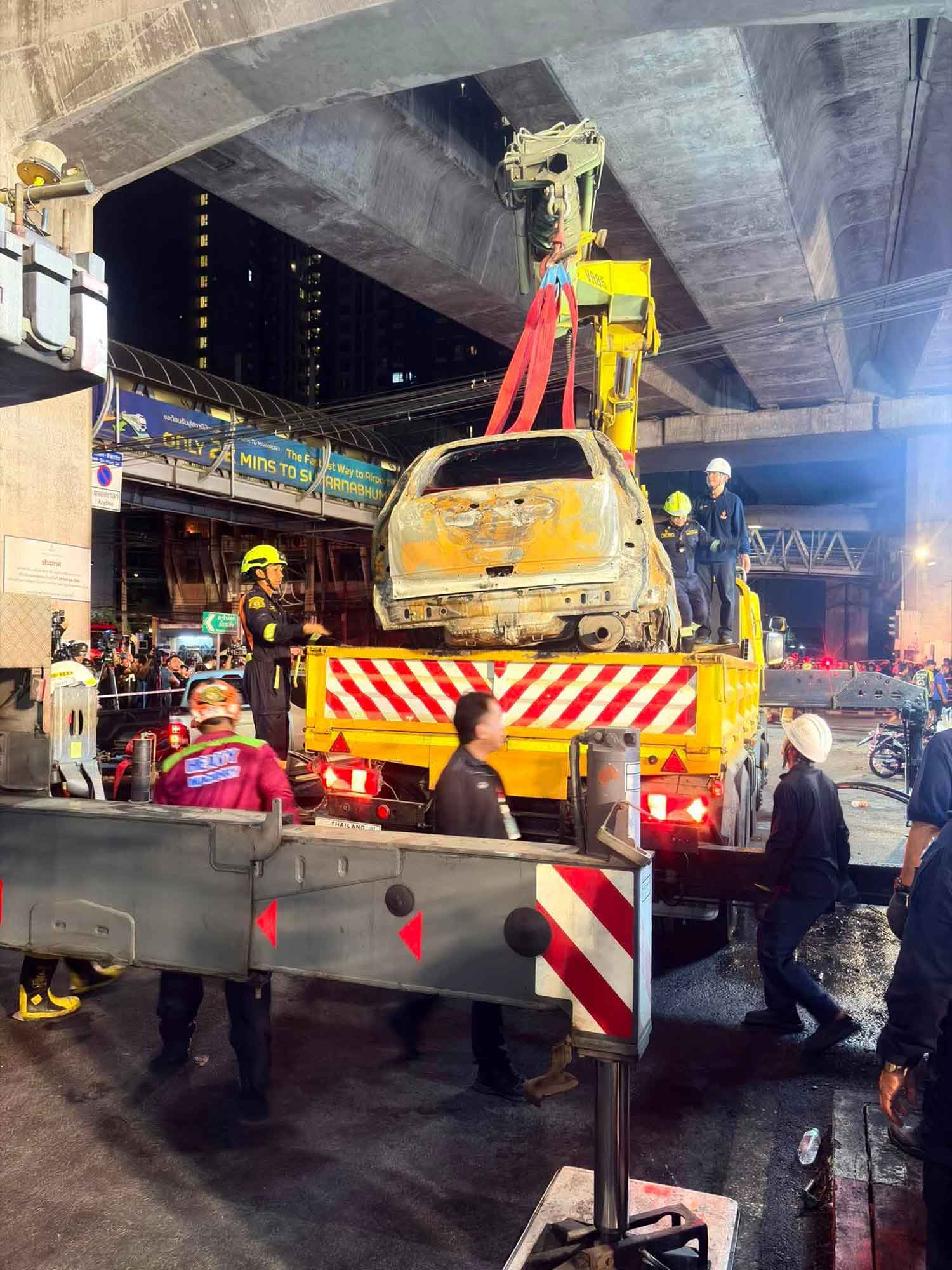 A damaged car is loaded on a truck during the debris removal operation late Saturday night. Photo: Bangkok Metropolitan Administration