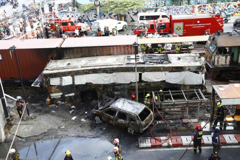 The halted freight train, the wrecked passenger bus and a damaged car after the collision at the level crossing on Asok-Din Daeng Road in Huai Khwang district, Bangkok, on Saturday afternoon. (Photo: Nutthawat Wichieanbut)