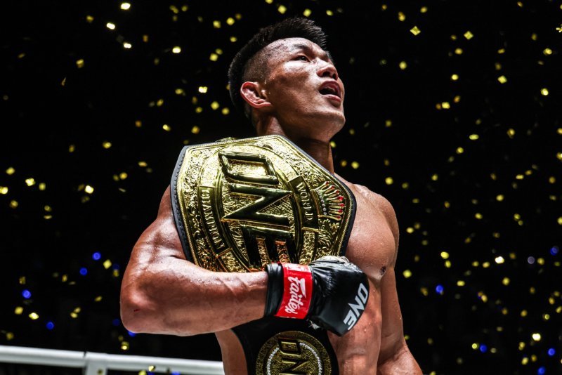 Tang Kai celebrates with his ONE Championship featherweight MMA world title