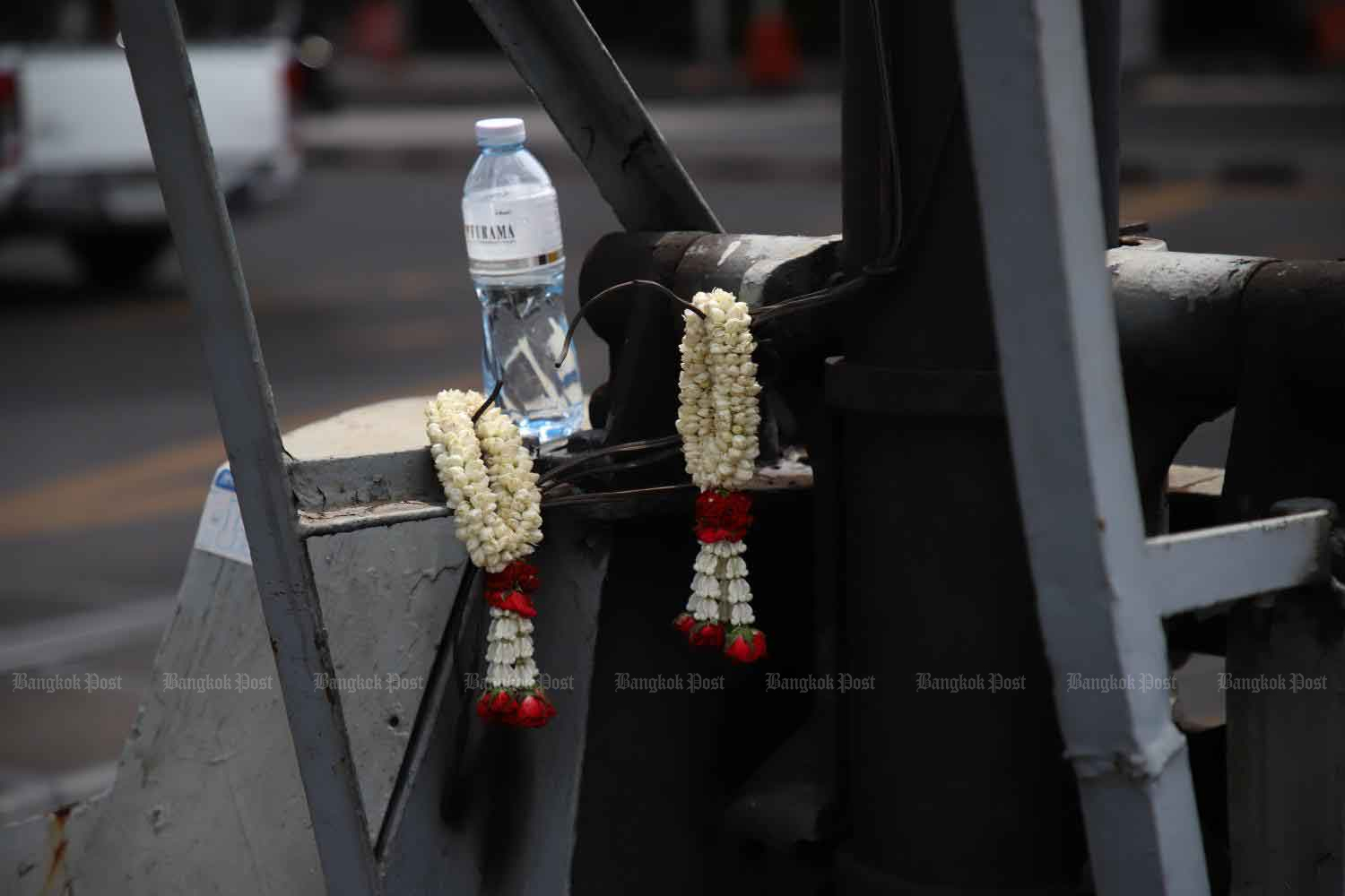 Garlands hung by victim's relatives are seen on the railway barrier at the site of Saturday's accident.