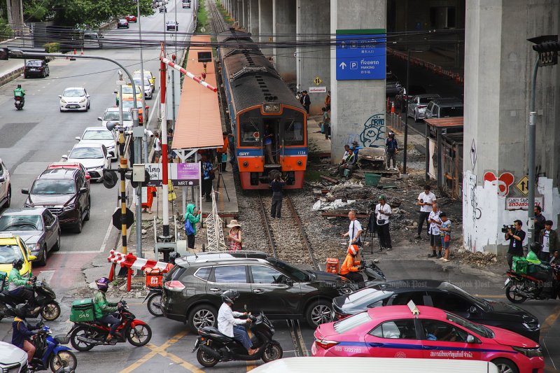 A train heading towards Bangkok waits for traffic to clear the railway crossing at Asok-Phetchaburi intersection. (Photos by Varuth Hirunyatheb)