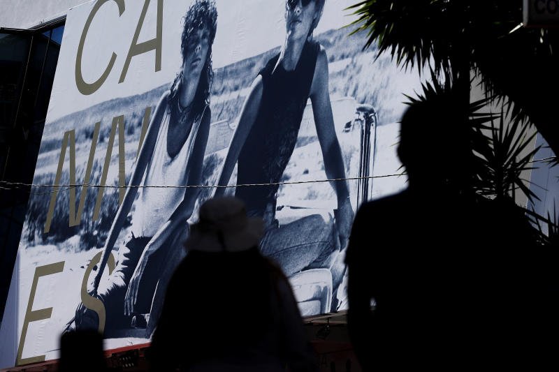 People walk past the Festival Palace with the official poster featuring actors Geena Davis and Susan Sarandon from Ridley Scott's road movie "Thelma & Louise" on its facade during the 79th Cannes Film Festival in Cannes, France, on May 16, 2026. (Photo: Reuters)