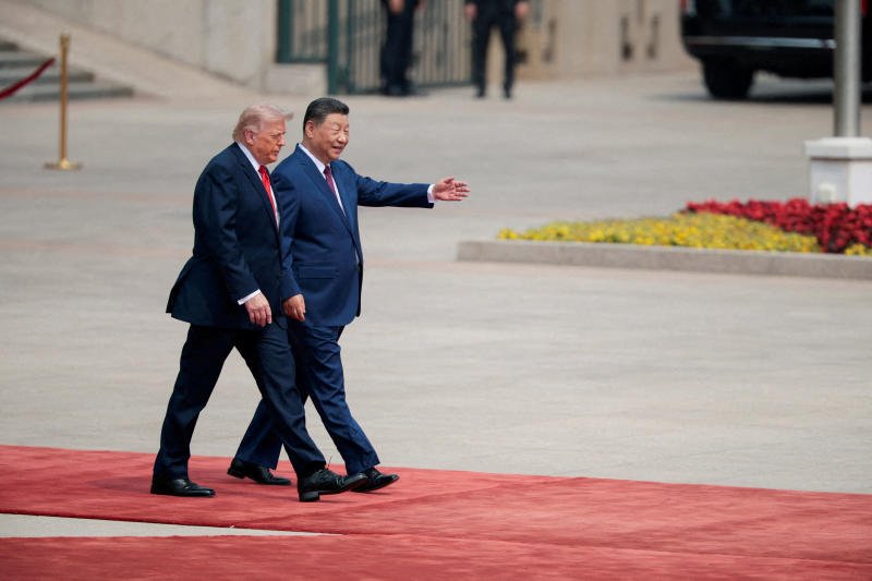 US President Donald Trump walks with Chinese President Xi Jinping upon arrival at the Great Hall of the People in Beijing on May 14. (Photo: Reuters)