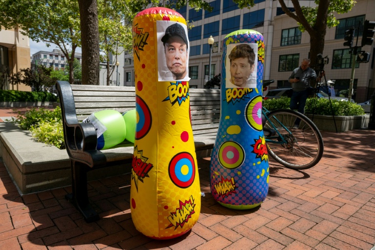 Inflatable punching bags with added pictures of Elon Musk and Sam Altman are seen outside the Ronald V. Dellums Federal Building and US Courthouse as the Musk v. Altman trial begins in Oakland, California in April.