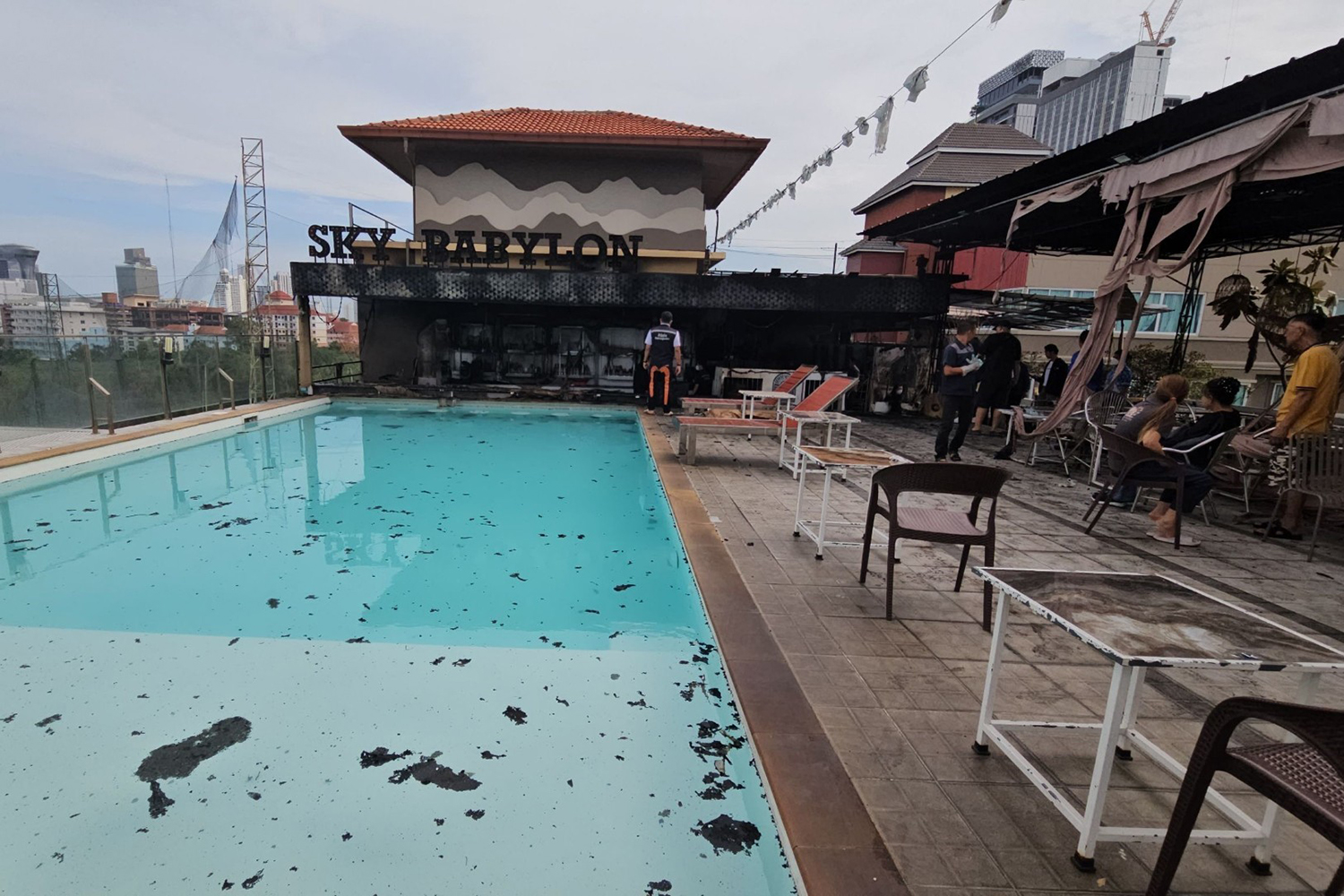 Fire debris is spread onto the swimming pool and on the floor of the rooftop of the building where the fire started. (Photo: Amporn Sangkaew)
