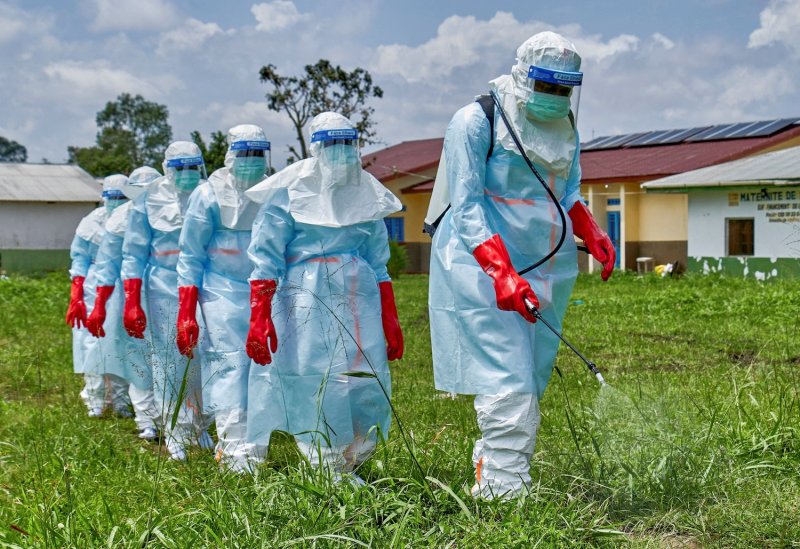 Red Cross workers walk in a formation as they disinfect the area around a hospital before handling the body of a person who died of Ebola, in Rwampara, Ituri province, Democratic Republic of Congo, on May 21, 2026. (Photo: Reuters)
