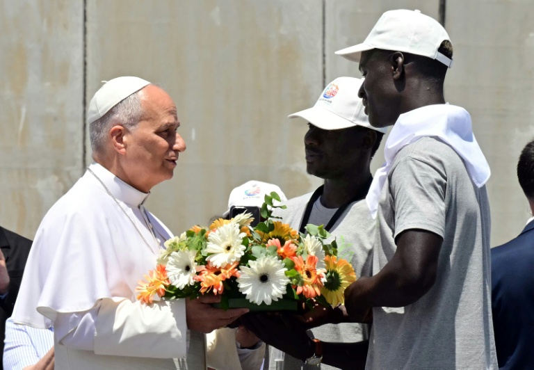 Pope Leo XIV is presented a wreath by two migrants, to make a floral tribute to remember all the migrants who perished during their journey, at the Port of Arguineguin on the Canary Island of Gran Canaria.(Photo: AFP)