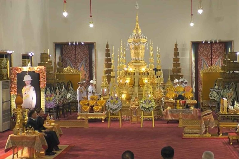Their Majesties the King and Queen, accompanied by HRH Princess Sirivannavari Nariratana Rajakanya and HRH Prince Dipangkorn Rasmijoti, attend funeral rites for HRH Princess Bajrakitiyabha Narendiradebyavati at Phimarn Rattaya Hall in the Grand Palace on Sunday. (Screen capture from TV Pool)