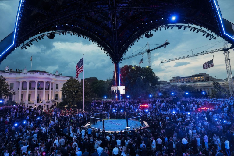 A screen shows US President Donald Trump walking with UFC President and CEO Dana White, as people attend UFC Freedom 250 on the South Lawn of the White House in Washington, DC, on June 14, 2026.