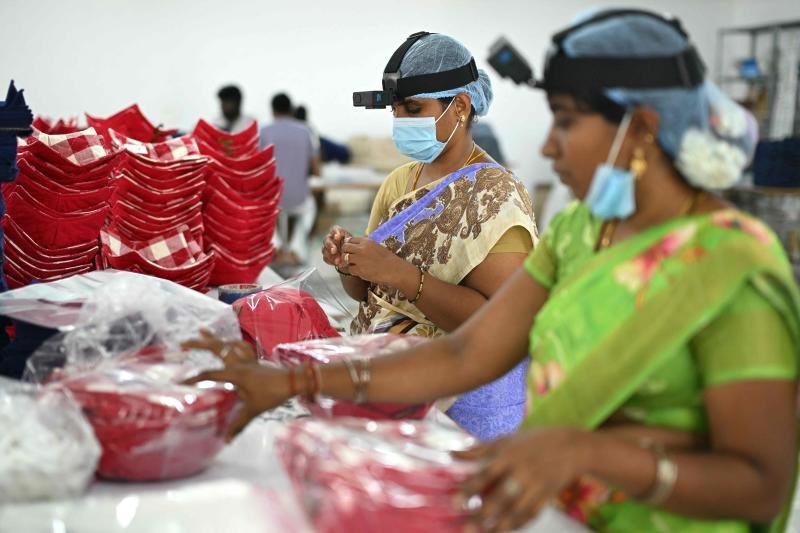 This photograph taken on May 13, 2026, shows workers wearing GoPro cameras on their heads recording actions through motion capture inside a factory in Tamil Nadu's Karur district. (Photo: AFP)