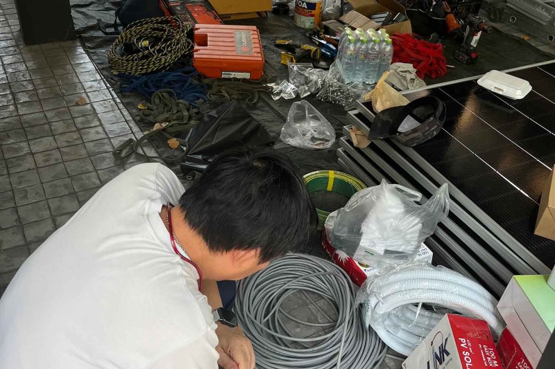 A householder checks solar rooftop components before installation at a house in Samut Prakan recently. (Photo supplied)