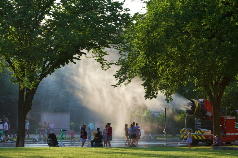 People battle the heat with misting stations during extreme heat along the National Mall in Washington, DC, on July 3, 2026