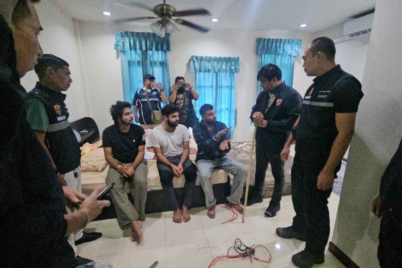 Police rescue three Indian victims seated on a bed at a house in Pattaya on Monday. One of them was sprayed with red paint to simulate bleeding. (Photo: Amporn Sangkaew)