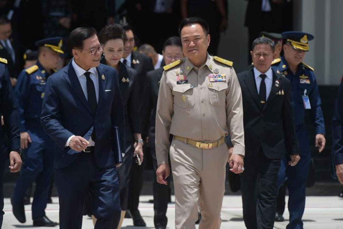 A group of officials in military uniforms and suits walking together outdoors.