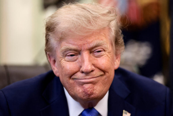A man in a dark suit smiling at the camera.