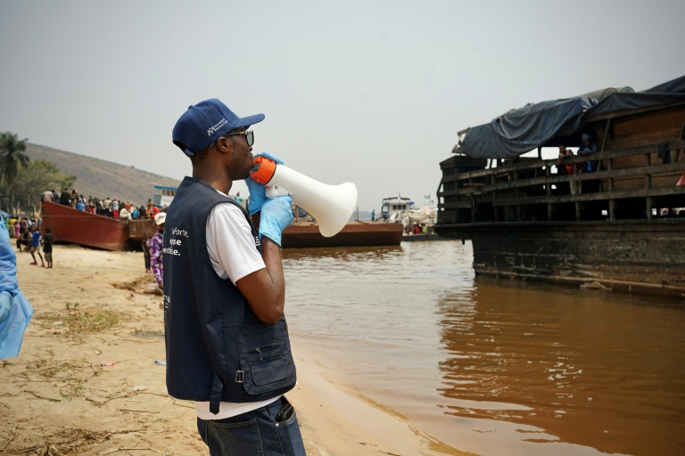 Yves Matwa, an Ebola outbreak response worker, tells passengers on Congo river ferries to brace for checks before they can enter the DR Congo capital Kinshasa