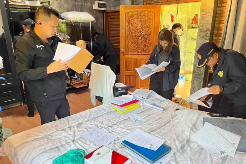 Police and administrative officials check documents at a raided house in Chai Prakan district, Chiang Mai, on Wednesday. Photo: Department of Provincial Administration