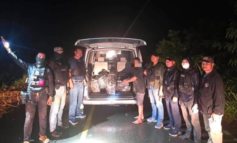 Police stand with the arrested driver at the open rear of the Volkswagen van carrying 4 million methamphetamine pills, in Amnat Charoen province on Saturday night. (Photos: สำนักข่าว 191 Facebook)