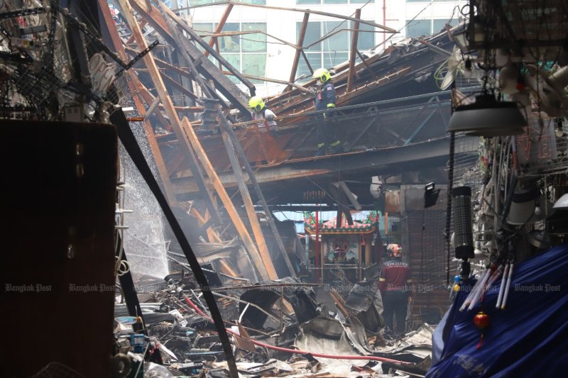 Firefighters inspect a building damaged by fire in Bangkok, Thailand. (Photo: Apichart Jinakul)