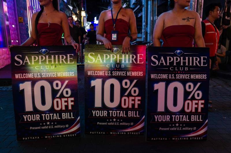 Hostesses advertise discounts to US service members of the nuclear-powered aircraft carrier USS Abraham Lincoln (CVN-72) at Walking Street in Pattaya on Wednesday. (Photo: AFP)