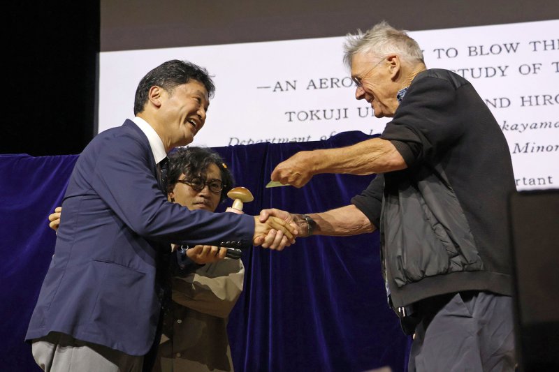 Miki Takahara (left), an Asahikawa Medical University professor, receives the 2026 Ig Nobel Prize for medicine, on behalf of the late Tokuji Unno in Zurich on Thursday. (Photo: Kyodo)