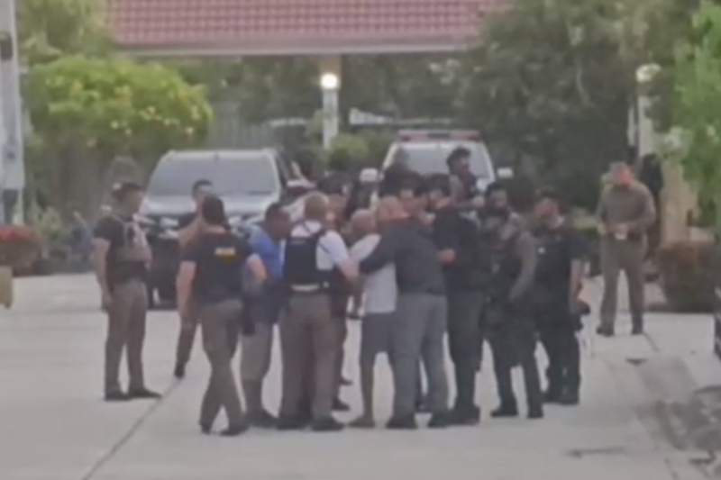 Police officers take gunman Tasapong Thongthat into custody on Thursday morning after an overnight siege at his house in Bang Lamung district of Chon Buri. (Photo: supplied/Wassayos Ngamkham)