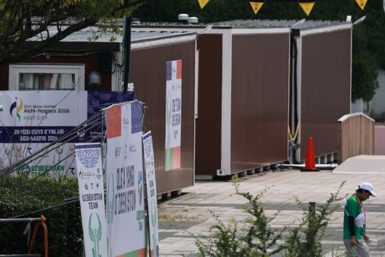 A man walks past temporary wooden container huts being used to house athletes for the 2026 Asian Games in Nagoya. (Photo: AFP)