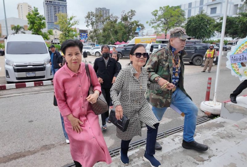 Chommanee Noichan, known as “Aunt Da”, left, and Ms Buakhai Sornsamut, centre, administrator of Hiang Phimsri's estate, arrive at Muang Khon Kaen police station to hear charges in connection with a dispute over land donated to a forest temple in Khon Kaen. (Photo: Chakkrapan Natanri)