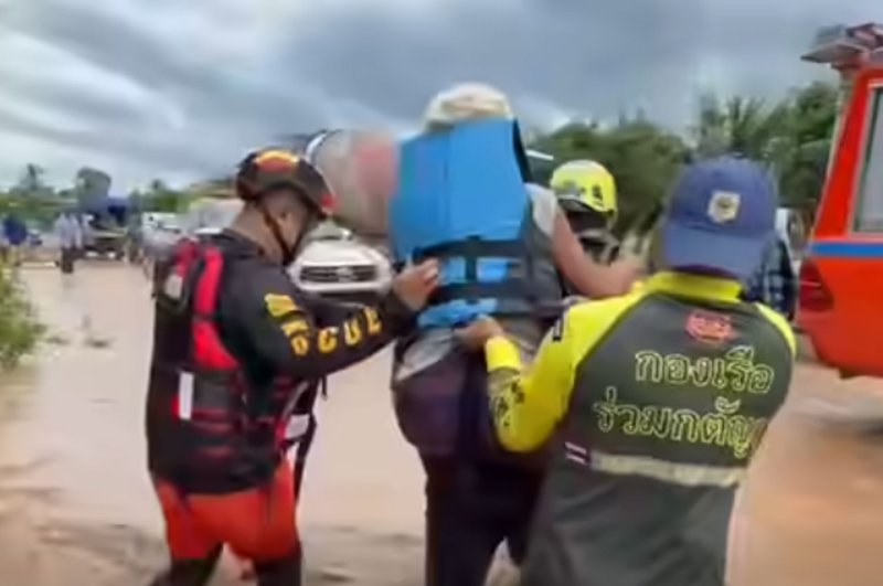 Rescue workers evacuate an elderly woman from her flooded house in Lom Sak district of Phetchabun province on Saturday. (Screengrab from Ruam Katanyu rescue team video)
