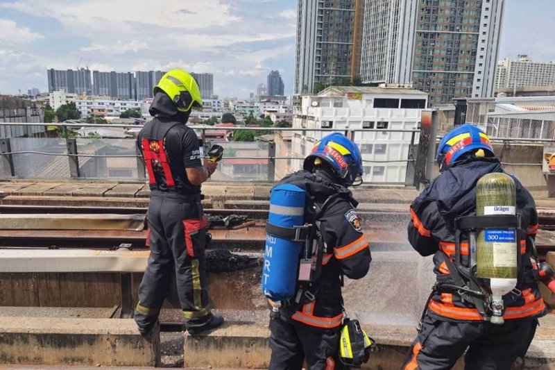 Firefighters quench the flames on the Blue Line track between Tao Poon and Bang O stations in Bangkok on Sunday. (photo: Mass Rapid Transit Authority)
