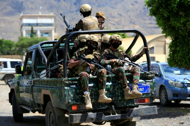 Yemen's Houthi armed forces patrol as Yemeni prisoners loyal to the Houthi authorities arrive in the capital Sanaa on September 12