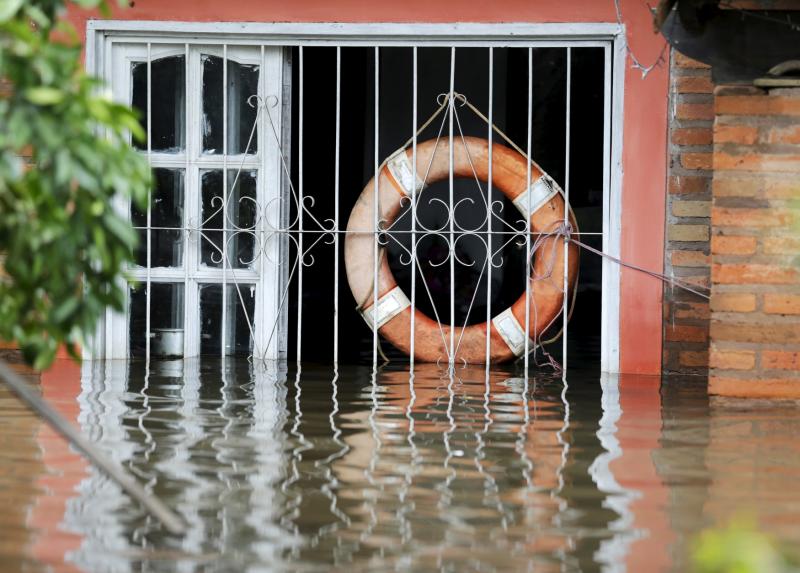 A lifebuoy hangs from a window in a flooded house in Asuncion on Dec 27, 2015. (File photo: Reuters)