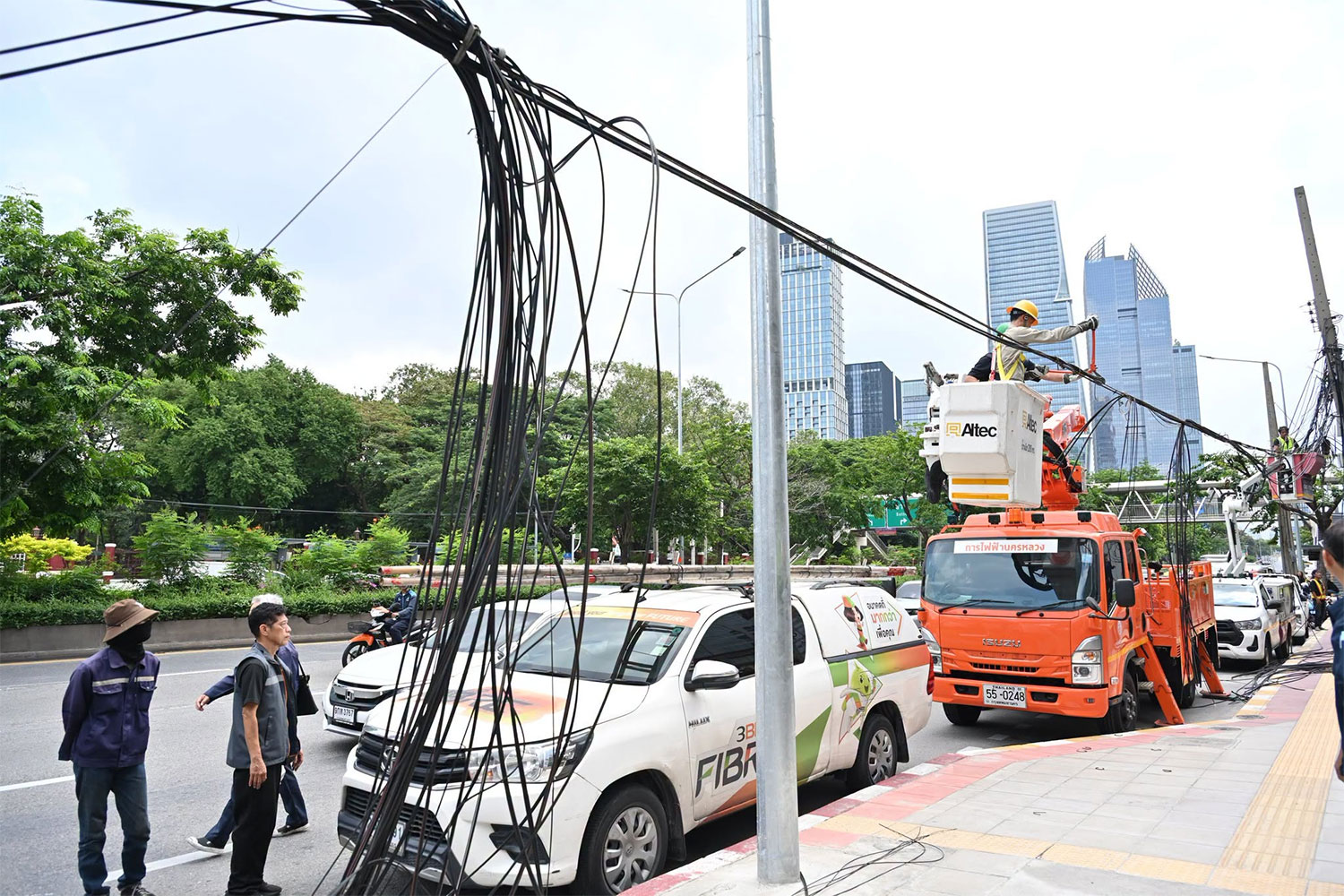 Technicians from Metropolitan Electricity Authority (MEA) and telecommunications agencies join the Bangkok Metropolitan Administration in moving power and cables on Rama IV Road on Wednesday. (Photo: Bangkok Metropolitan Administration)