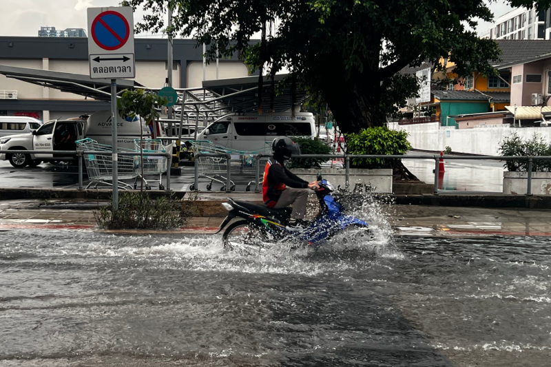 A motorcycle taxi driver navigates floodwaters in Klong Toey district after heavy rain in Bangkok on Wednesday. (Photo: Pattanapong Hirunard)