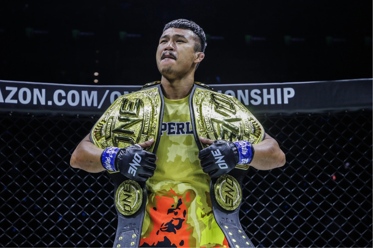 Superlek poses with his flyweight kickboxing and bantamweight Muay Thai belts after becoming a two-sport ONE Championship titleholder in Denver