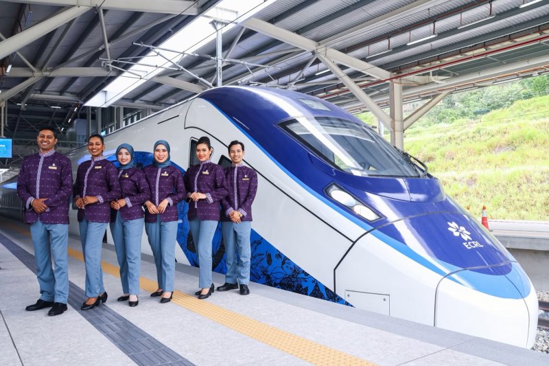 Crew members stand beside a train to be operated on a new project called the East Coast Rail Link in Malaysia. (Photo: East Coast Rail Link Facebook page)
