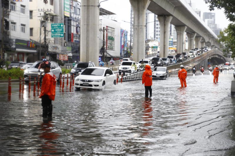 Police manage traffic on a flooded road in Bang Khen district of Bangkok following continuous heavy rain on Friday. (Photo: Nutthawat Wichieanbut)
