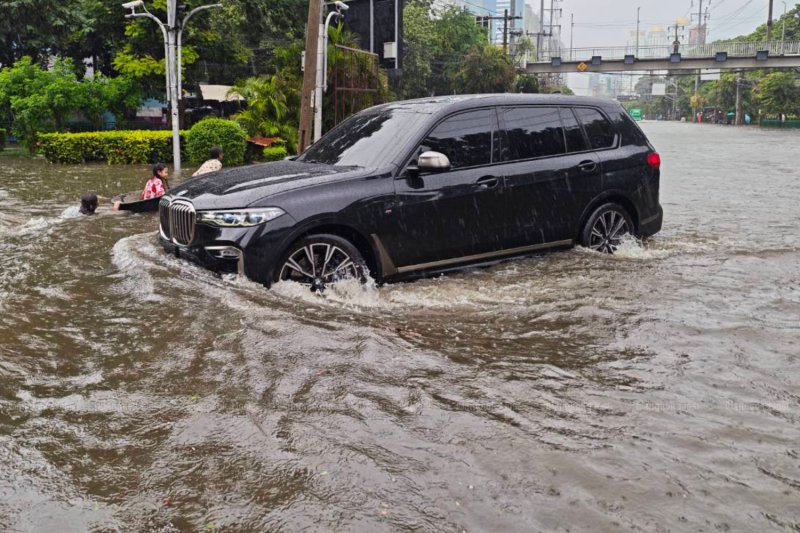 A BMW battles floodwaters on Phetchaburi Road in Bangkok on Saturday. (Photo: Jetjaras Na Ranong)