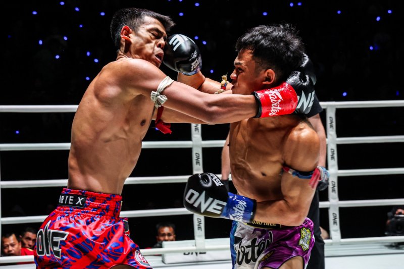 Panpayak Jitmuangnon (left) lands a punch on Lamnamoonlek Torfunfarm during their flyweight kickboxing bout at Lumpinee Stadium (Large)