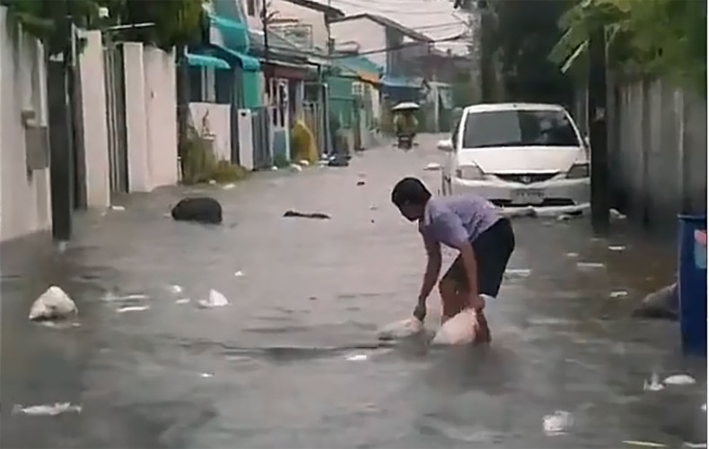 Schoolboy hailed for clearing rubbish from flooded city street