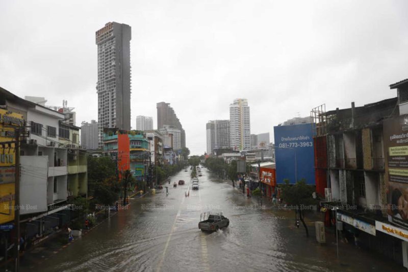 A policeman stands on deeply flooded Nawamin Road near Bang Kapi intersection in Bang Kapi district, Bangkok, on early Monday morning. (Photo: Lat Phrao police station)