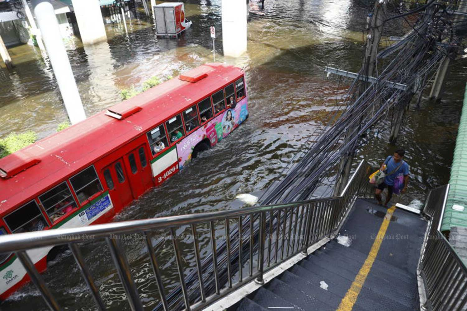 Non-air-conditioned buses remain as the only left resort for commuters in flooded Bang Kapi district on Tuesday. Nutthawat Wicheanbut