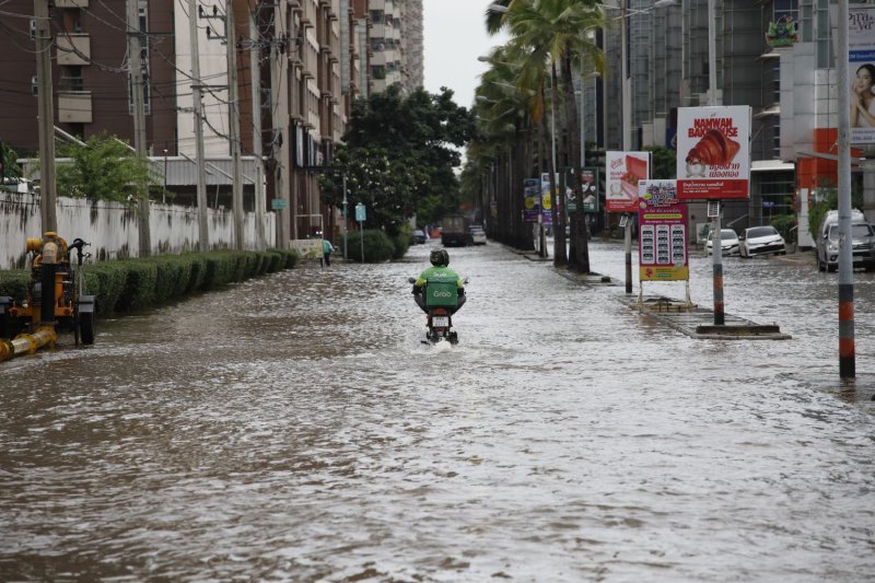 A Grab delivery man rides through flooded roads at Muang Thong Thani in Nonthaburi.