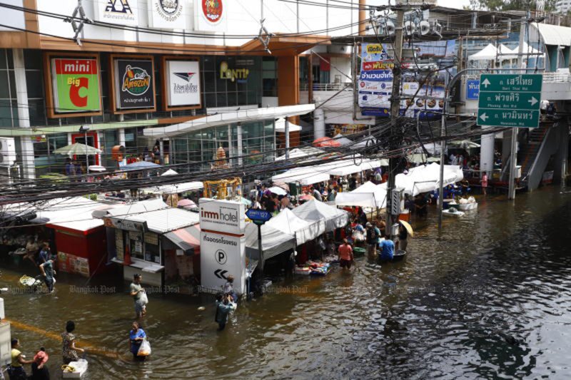 Customers wade through floodwater at Bang Kapi fresh market on Soi Lat Phrao 127 in Bangkok on Tuesday. (Photo: Nutthawat Wichieanbut)