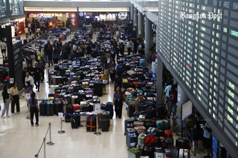 Luggage piles up on the second floor of the Suvarnabhumi airport passenger terminal after overflowing the conveyor belts on Tuesday. (Photo: Nutthawut Wichienbut)