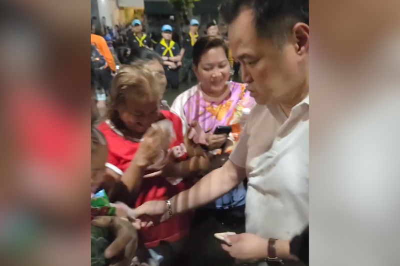 Prime Minister Anutin Charnvirakul was seen handing cash to residents while visiting flood victims in Bangkok's Sai Mai district on Tuesday. (Photo: Survive - สายไหมต้องรอด)